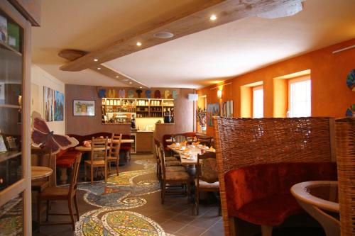 a restaurant with tables and chairs in a room at Kunsthof Eibenstock in Eibenstock