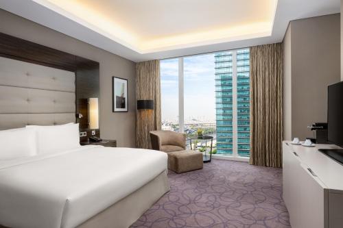 a hotel room with a bed and a large window at Hilton Riyadh Hotel & Residences in Riyadh