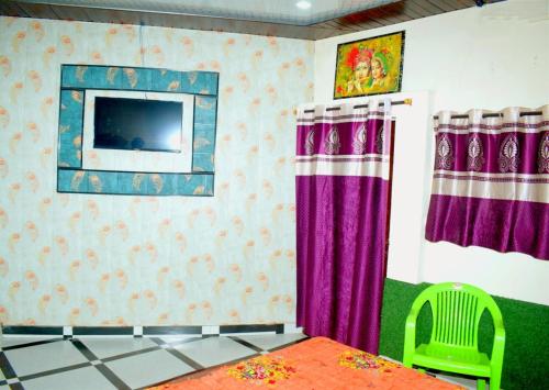 a living room with a tv and purple curtains at Radhey Krishna home stay in Mathura