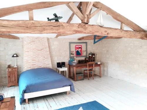 une chambre avec un lit et un bureau dans l'établissement Maison familiale de charme 11 personnes dans le Médoc, à Saint-Germain-dʼEsteuil