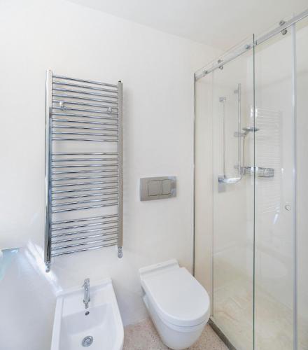 a white bathroom with a toilet and a shower at Masseria Alchimia in Fasano