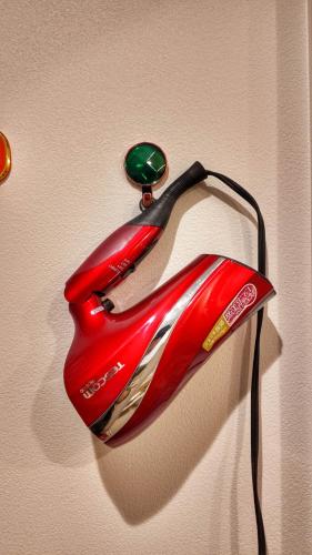 a red telephone is hanging on a wall at Sunflower 民泊 in Tokyo
