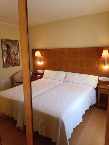 a bedroom with two beds and two lamps at Hotel Villa de Larraga in Larraga