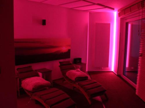 una habitación con luces rosas y sillas en Burk´s Scheune Comfortable holiday residence 