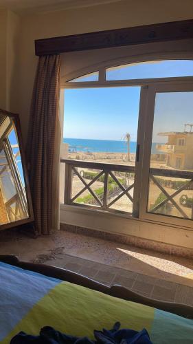 a bedroom with a view of the beach from a window at فيلا للرفاهية Blu Lagon in Ras Sedr