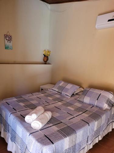a bedroom with a bed with towels on it at Brisa da Serra Hotel Pousada Pirenopolis in Pirenópolis