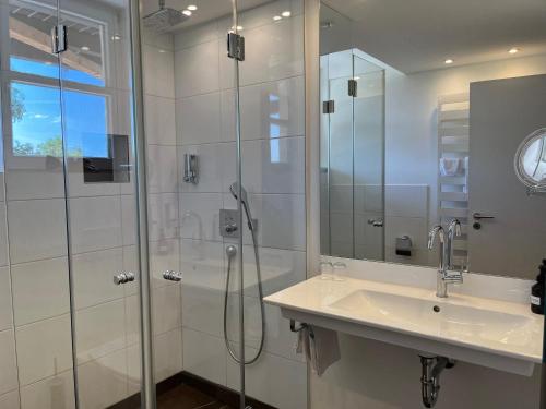 a bathroom with a shower and a sink and a mirror at WESTSIDE Hotel in Munich