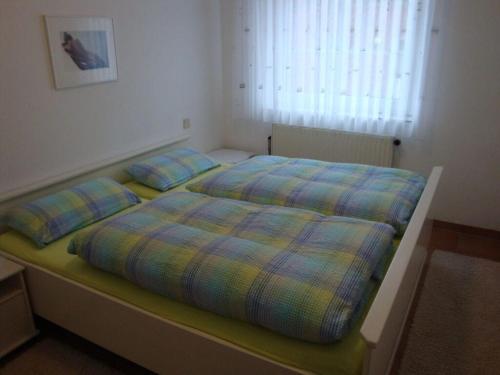 ein Bett mit zwei Kissen darauf in einem Schlafzimmer in der Unterkunft Nice holiday home near town centre in Juist