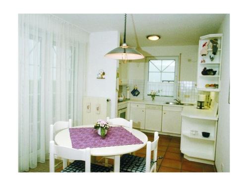 eine Küche mit einem Tisch und Stühlen sowie ein Esszimmer in der Unterkunft Nice holiday home near town centre in Juist
