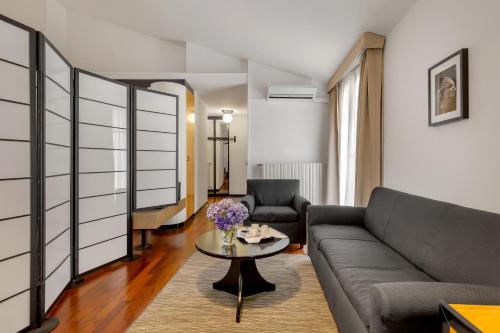 uma sala de estar com um sofá e uma mesa em Hotel Ancora em Verbania