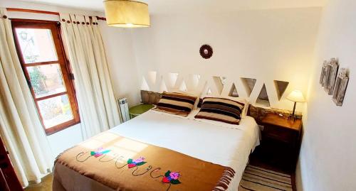 una camera con un grande letto bianco di Los Arcabuceros Posada Boutique a Tilcara