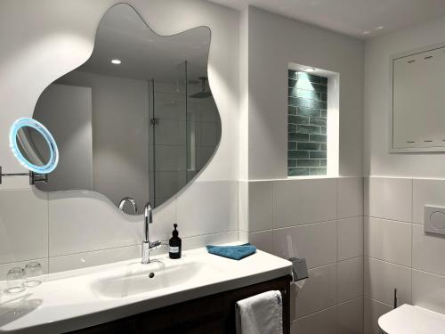 a white bathroom with a sink and a mirror at WESTSIDE Hotel in Munich
