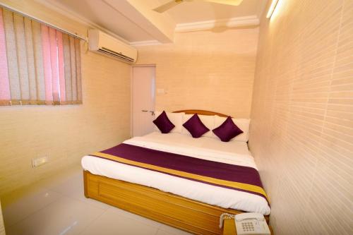 Un pat sau paturi într-o cameră la Ganpati Hotel