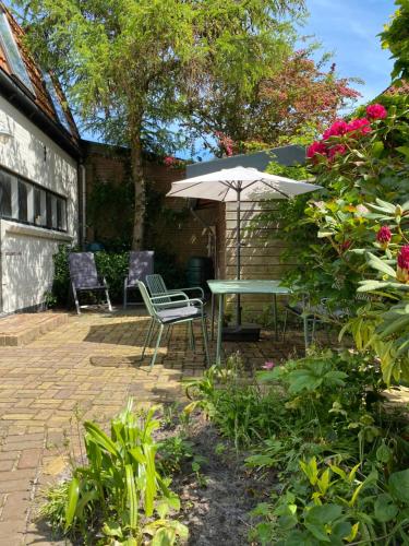 a patio with a table and chairs and an umbrella at Appartement Oldenburg in Bergen