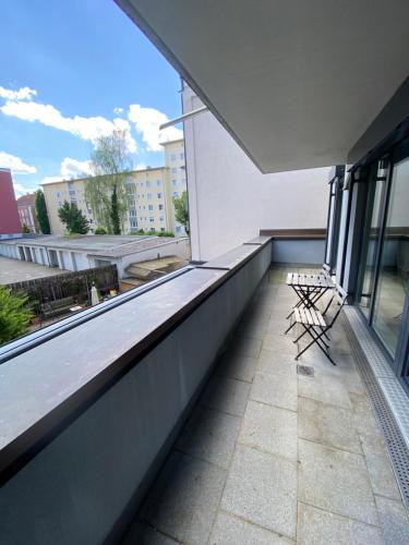 einen Balkon mit zwei Stühlen auf einem Gebäude in der Unterkunft 21rooms in Ingolstadt