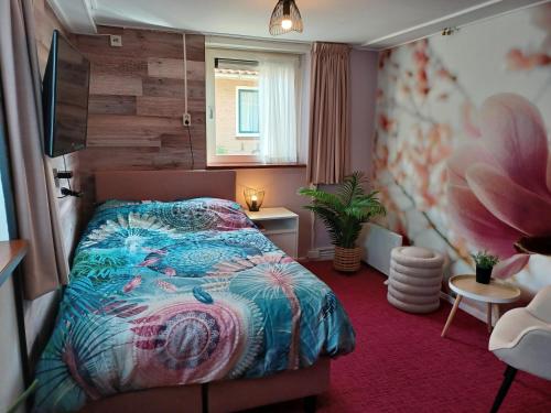 Hotel Dichtbijzee في Oosterend: غرفة نوم صغيرة بها سرير ونافذة