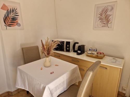a kitchen with a table with a white table cloth on it at Auberge Sainte Marguerite in La Garde