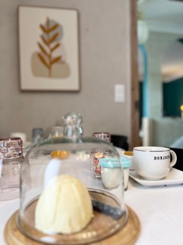a glass dish of food on a table with a cup at Le Clos Gabrielle in Châtellerault