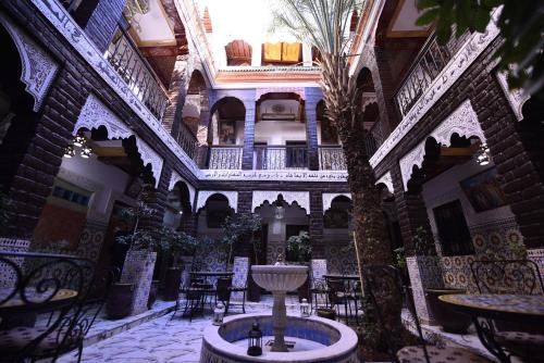 a courtyard with a fountain in the middle of a building at Hotel Riad Fantasia in Marrakech