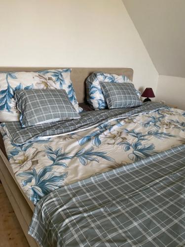 a bed with blue and white sheets and pillows at BG Apartments in Somogyhatvan