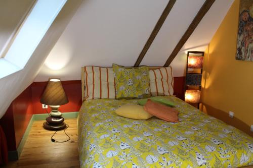 - une chambre avec un lit et une couette jaune dans l'établissement le gîte du bain des oies, à Sauveterre