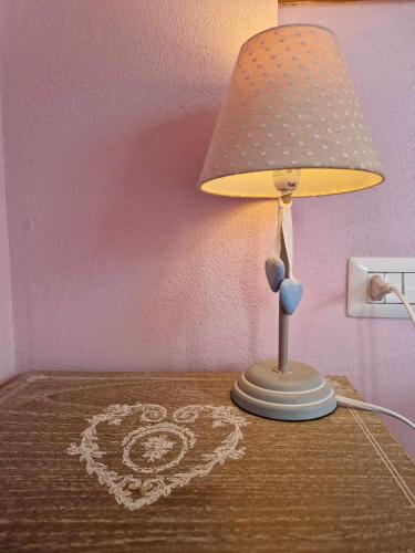 a table with a lamp and a heart on it at Foresteria Villa Simona in Colico
