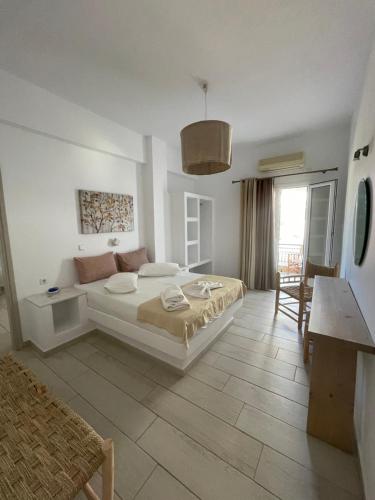 a white bedroom with a bed and a table at Asteras in Antiparos Town