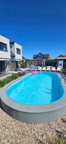 a large swimming pool in the middle of a yard at Domki-Apartamenty Polanki 2 - Sauna, Jacuzzi, Podgrzewany Basen in Łeba