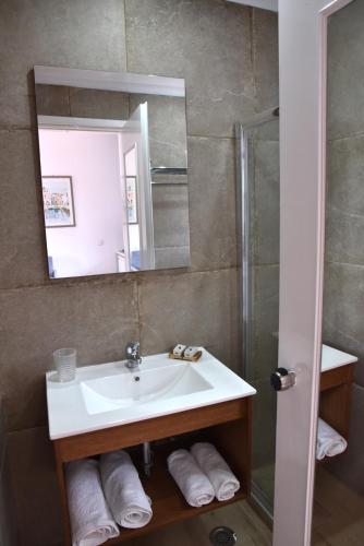 a bathroom with a sink and a shower and a mirror at Boutique Hotel Tilos Mare in Livadia