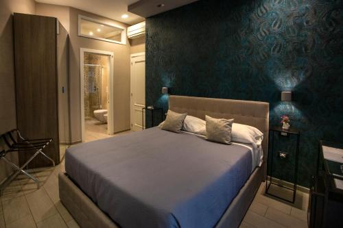 een slaapkamer met een bed met een blauwe muur bij Bell's in Napels
