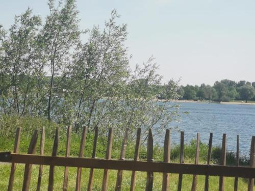valla de madera con vistas al lago en Tiny Haus Auszeit am See en Lathum