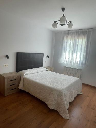 Dormitorio blanco con cama y lámpara en Apartamento en Carreña de Cabrales, en Carreña