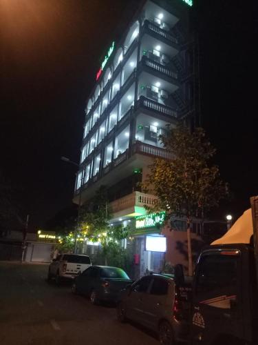 a tall building with cars parked in front of it at night at Biển Nhớ Hotel & Coffee in Phan Thiet