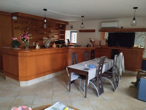 a dining room with a table and a kitchen at Maison Tournebride in Meillac