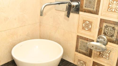 bagno con servizi igienici bianchi in una cabina di Hotel MM Continental a Varanasi