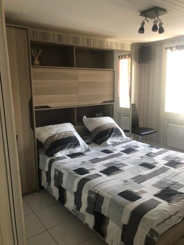 une chambre avec un lit avec une couette noire et blanche dans l'établissement Villa à la porte des landes, à Casteljaloux