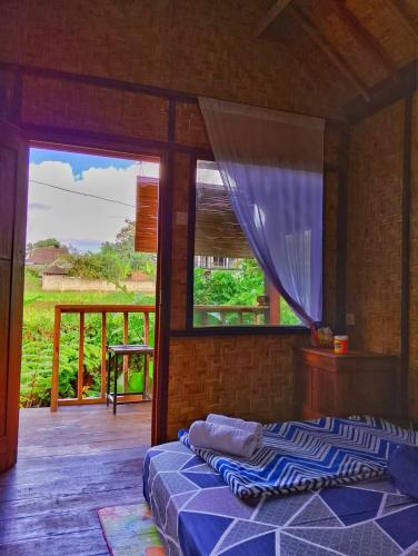 a bedroom with two beds and a window at Citra Homestay in Tetebatu