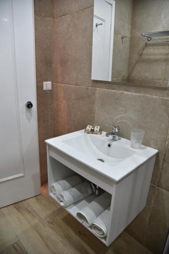 a bathroom with a white sink and a mirror at Boutique Hotel Tilos Mare in Livadia