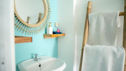 une salle de bain avec un lavabo et un miroir dans l'établissement The White Bay Lombok, à Kuta Lombok