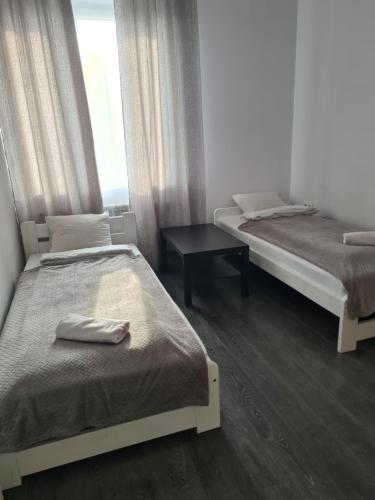 um quarto com duas camas e uma mesa e uma janela em Katowice Airport Host em Mierzęcice