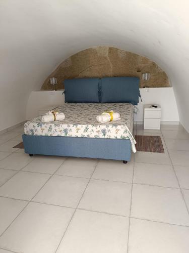 1 dormitorio con 1 cama azul en una habitación blanca en Casa Le Soleil, en Isquia
