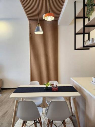 a dining room with a table and four chairs at Antara Lima Homestay Putrajaya in Putrajaya