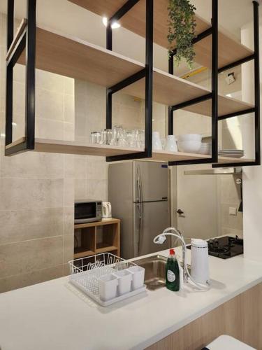 a kitchen with a sink and a refrigerator at Antara Lima Homestay Putrajaya in Putrajaya