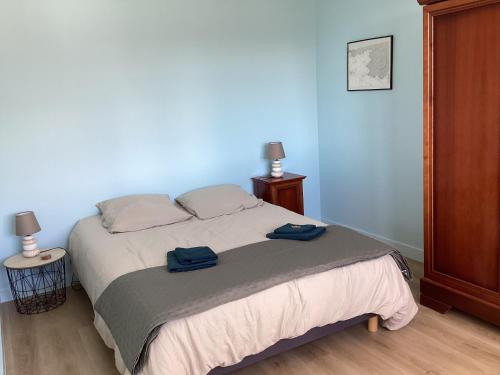 ein Schlafzimmer mit einem Bett mit zwei Handtüchern darauf in der Unterkunft Ker LN in Saint-Nazaire