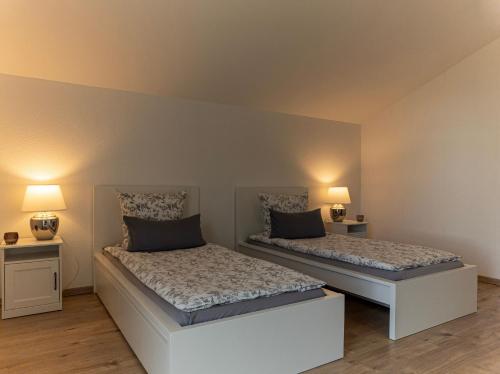 2 camas en una habitación con 2 lámparas en Ferienwohnung Elena en Tettnang