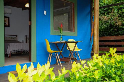 帕拉蒂的住宿－Sitio Namaste Paraty，蓝色的房子,配有桌子和黄色椅子