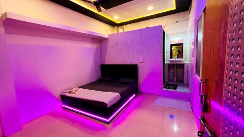 um quarto com uma cama com luzes cor-de-rosa em PALLAV GUEST HOUSE em Ujjain