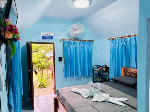 a room with a bed with two white towels on it at Adventure Point Resort By Sali in Kaeng Krachan