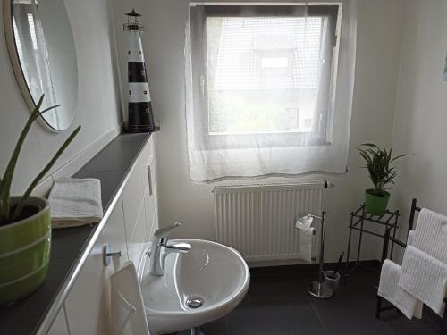 ein Bad mit einem Waschbecken und einem Fenster in der Unterkunft Ferienwohnung Erftalblick in Hardheim