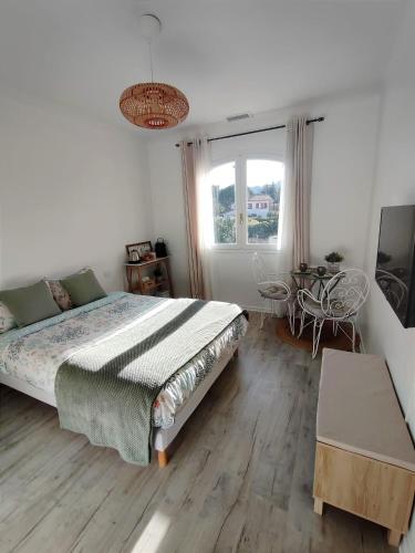 une chambre avec un lit, une table et une fenêtre dans l'établissement Chambre climatisée entre mer et montagne, avec SDB et WC privatifs, à Laroque-des-Albères